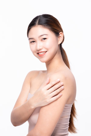 Beautiful Asian woman touching soft cheek smile with clean and fresh skin Happiness and cheerful with positive emotional,isolated on white background,Beauty Self Care and Cosmetics Conceptの写真素材