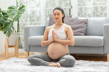 Happy Calm Pregnant Woman deep breath with fresh air do yoga lotus pose comfortable at home,Pregnancy of young woman relax with yoga to meditation for healthy life,Yoga Motherhood and Pregnant Conceptの写真素材