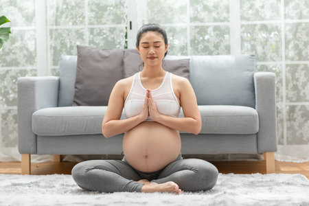 Happy Calm Pregnant Woman deep breath with fresh air do yoga lotus pose comfortable at home,Pregnancy of young woman relax with yoga to meditation for healthy life,Yoga Motherhood and Pregnant Conceptの写真素材