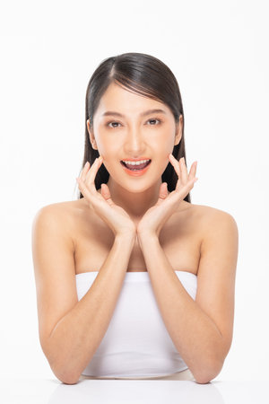 Beautiful Asian woman touching soft cheek smile with clean and fresh skin Happiness and cheerful with positive emotional,isolated on white background,Beauty Cosmetics and spa facial treatment Conceptの写真素材