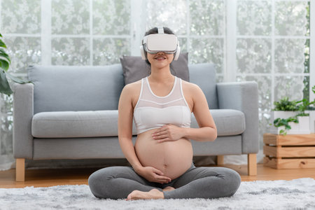 Happy Pregnant woman using virtual reality glasses for practice tutorial to take care of a newborn baby.Asian Pregnant woman ware goggle using VR enjoy at home.Pregnancy Metaverse Technologyの写真素材
