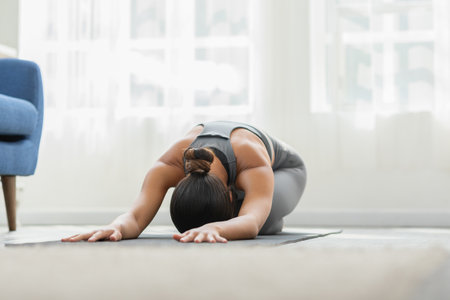 Asian woman wearing green sportwear doing Yoga exercise,Yoga Childâ€™s pose or Balasana,Calm of...