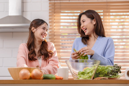 Couple LGBTQ lover cooking in kitchen together smile and laughing. Happiness and tender moment quality time at home. LGBTQ+ Conceptの写真素材