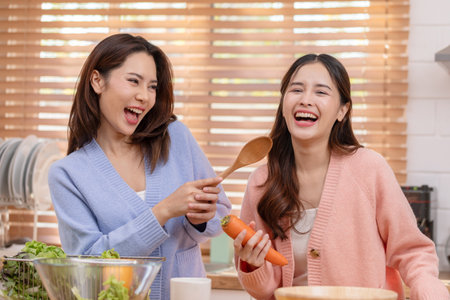Couple LGBTQ lover cooking in kitchen together smile and laughing. Happiness and tender moment quality time at home. LGBTQ+ Conceptの写真素材