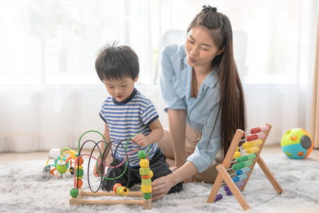 Asian Mother and Child Playing with Educational Toys at Homeの写真素材