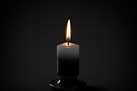 Burning candle on black background, closeup. Space for textの素材