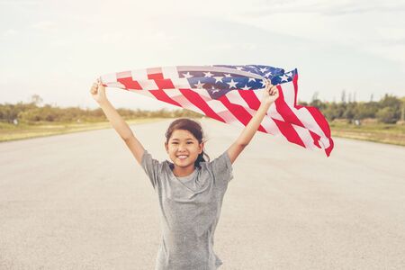 Happy asian little girl with American flag USA celebrate 4th of Julyの写真素材
