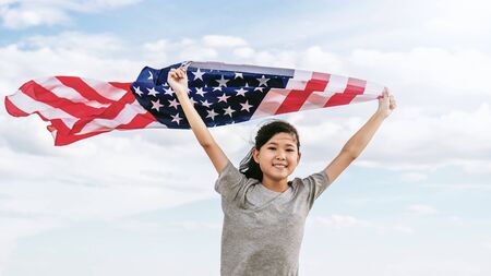 Happy asian little girl with American flag USA celebrate 4th of July