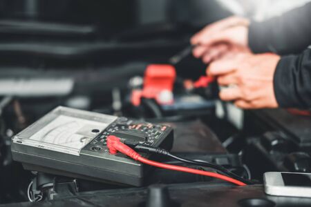 Technician Hands of car mechanic working in auto repair Service and Maintenance car battery