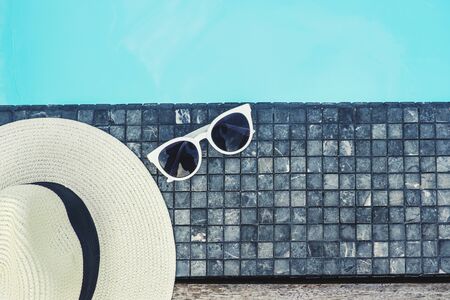Hat and sunglass on luxury swimming pool tropical beach resort , summer conceptの写真素材