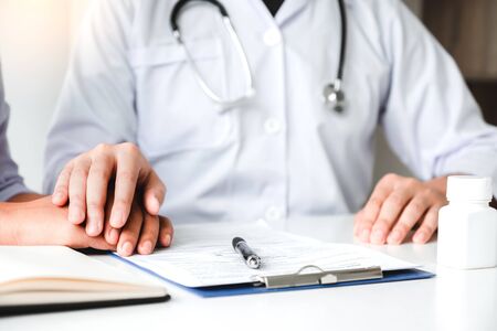 Friendly doctor hold patient hand for care and comfortingの写真素材