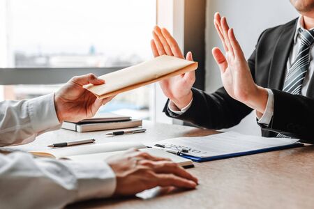 Corruption and Bribery,Businessman manager refusing receive money from Business man passing money dollar bills to deal contractの写真素材