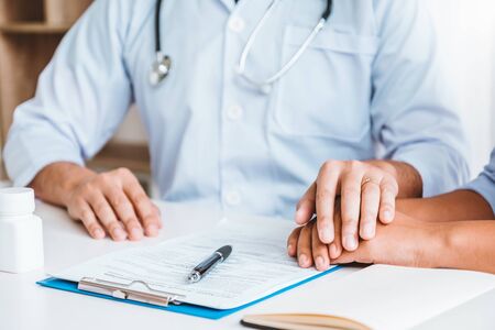 Friendly doctor hold patient hand for care and comfortingの写真素材