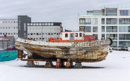 An old wooden boat on blocks awaiting repair in the waterfront district of Reykjavik Iceland.の写真素材