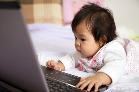 Baby is playing a computerの写真素材