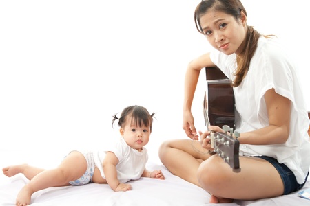 Mother is playing a guitar for her baby