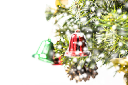 Red and green and Gold Christmas bell decoration hanging from Christmas tree.Christmas tree background and Christmas decorations with snow, blurred, sparking, glowing. Happy New Year and Xmas theme.の写真素材