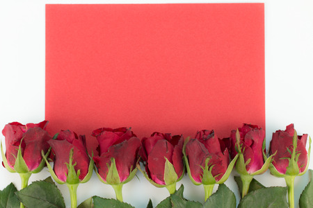 Close up of red roses on a wooden background with Blank Message Sign for Your Text or Message. Red Greeting card with a red roses and space for text using as love, valentine day concept.の写真素材
