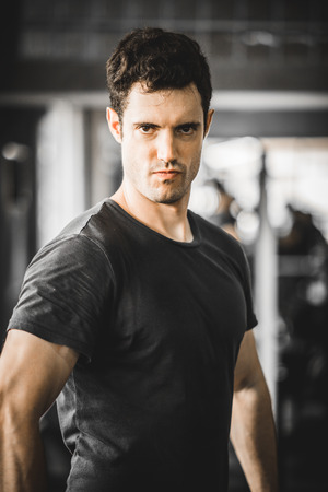 Fit caucasian handsome young man and big muscle in sportswear. Portrait of young man action after exercise class in a gym. Healthy sports lifestyle, Fitness concept. with copy space for your text.の写真素材