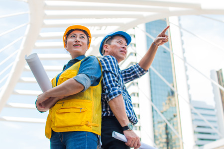 Portrait of team partners industrial engineer standing and looking to camera wear safety helmet with...