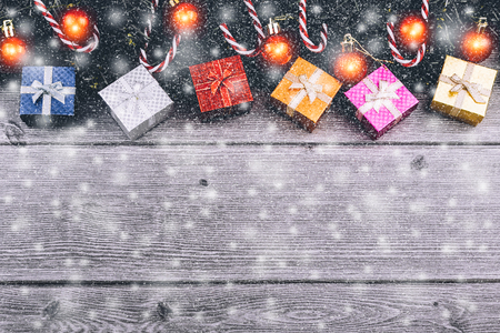 Christmas background with decorations, gift boxes, tree branches and red baubles with abstract snow on wooden background. With copy space and using for your text and greeting card christmas and new year festival.の写真素材