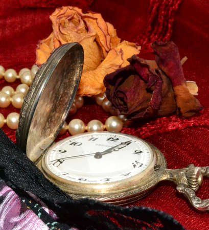 Antique clock with stuffed roses and pearl necklaceの写真素材