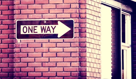 One way sign on a red brick wall