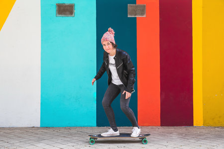 woman with cap and skateboard with mobile phoneの写真素材