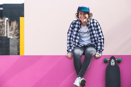 woman with cap and skateboard with mobile phoneの写真素材