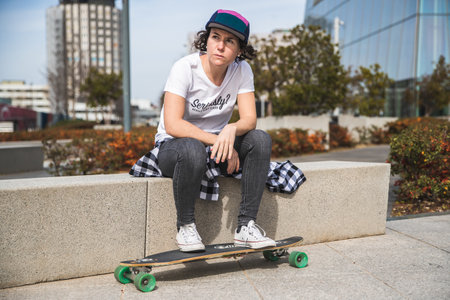 woman with cap and skateboard with mobile phoneの写真素材