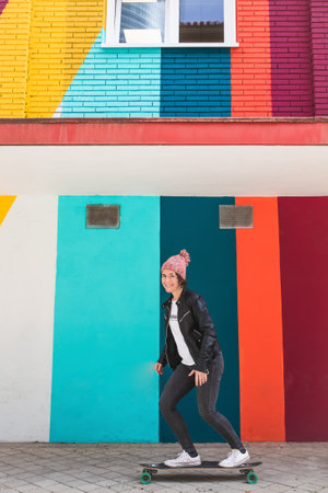 woman with cap and skateboard with mobile phoneの写真素材