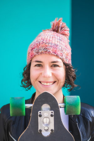 woman with cap and skateboard with mobile phoneの写真素材