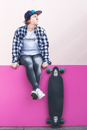 woman with cap and skateboard with mobile phoneの写真素材