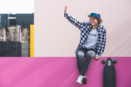 woman with cap and skateboard with mobile phoneの写真素材