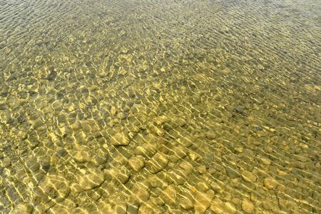 Water background with stones in pond