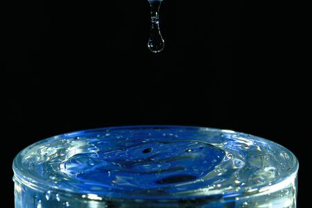 Drop of drop on glass of water