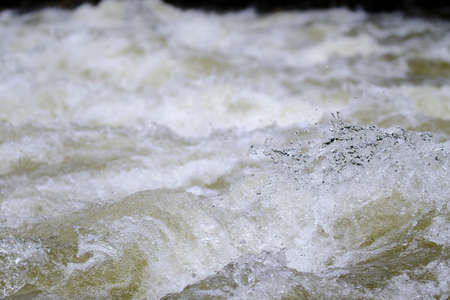 Texture of water in a natural state, in a river when splashing against the stones.の写真素材