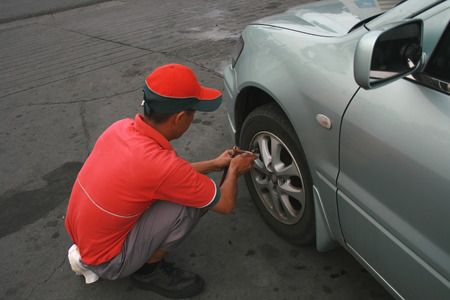 station crew providing free tire air checkupの写真素材
