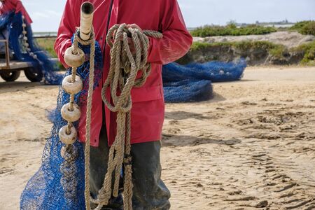 Fishermen manipulating fishing net to fish in river