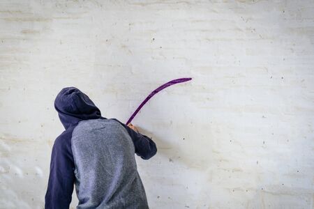 Young man with spray paint to paint on wall