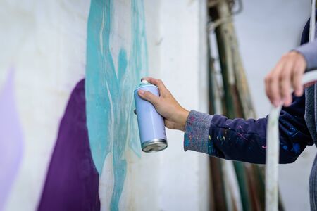Young man with spray paint to paint on wall