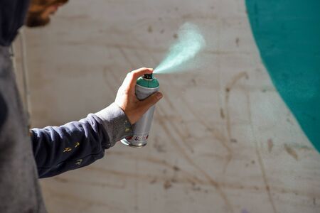Young man with spray paint to paint on wallの写真素材