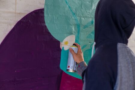 Young man with spray paint to paint on wall