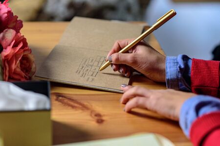Woman's hands writing in notebook