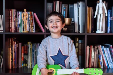 Little boy playing with green guitarの写真素材