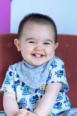 Funny baby sitting on chairの写真素材