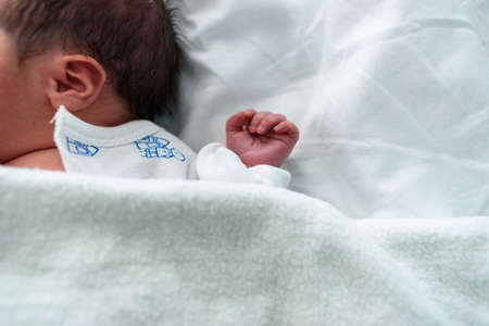 Small hand of newborn baby in hospital cribの写真素材