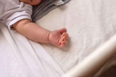 Small baby asleep peacefully in crib in room at home.の写真素材