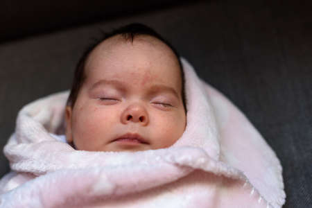 Small baby asleep peacefully in crib in room at home.