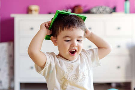 Cute little boy playing in room at home with various toysの写真素材